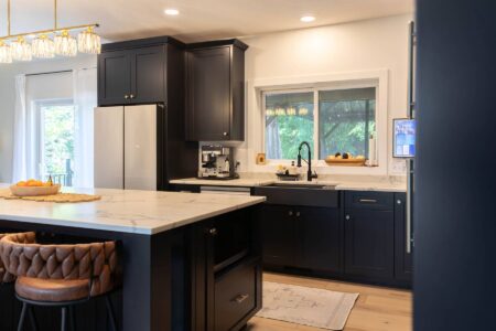 Black shaker cabinets surrounding the kitchen sink and window by Crosby Fine Cabinetry Belle Plaine MN