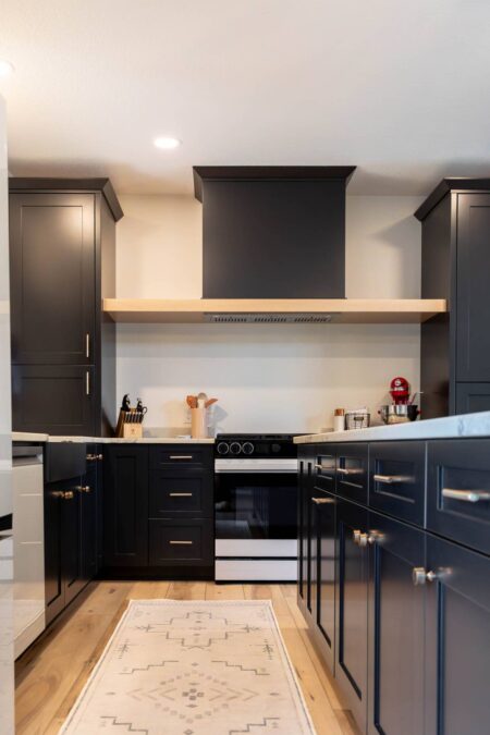 Custom black range hood with natural oak accent by Crosby Fine Cabinetry Belle Plaine MN