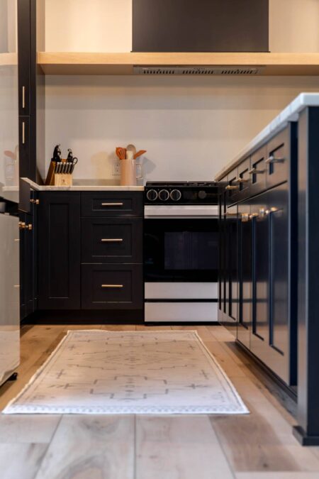 Custom black range hood with natural oak accent by Crosby Fine Cabinetry Belle Plaine MN
